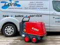 A red Ehrle HD pressure washer standing in front of an Idro Power van.